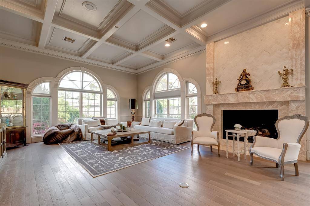 Expansive game room featuring elegant coffered ceilings and a cozy fireplace.