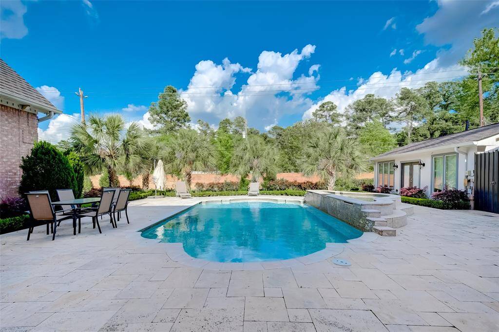Experience tranquility with a sparkling pool surrounded by lush greenery.