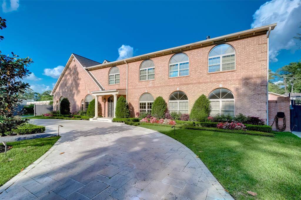 Elegant circular driveway framed by lush, well-maintained landscaping.