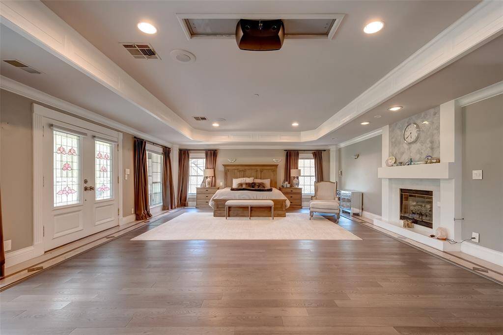 Luxurious master suite, featuring spacious elegance and a cozy fireplace for the ultimate retreat.