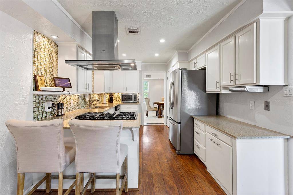 The litchen features a 5-burner gas stove, stainless steel appliances and Silestone countertops.