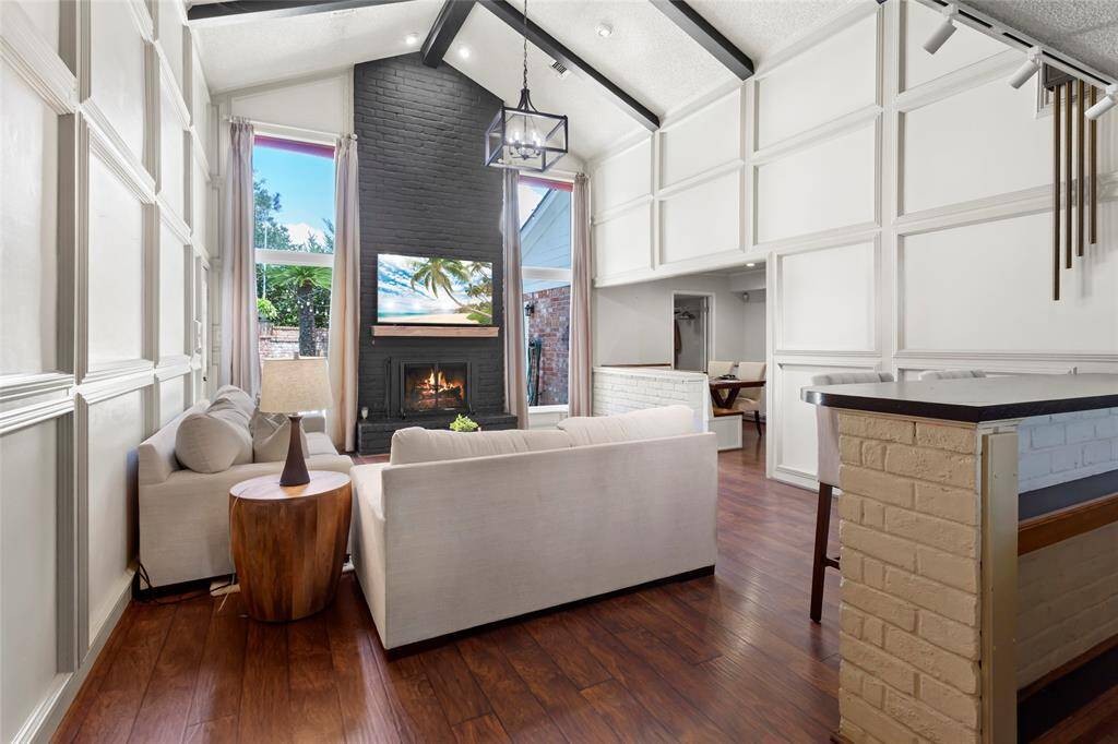 The large family room features 20 foot cathedral ceiling with wood beams and floor-to-ceiling wainscoting which provides a dramatic and visually impactful design