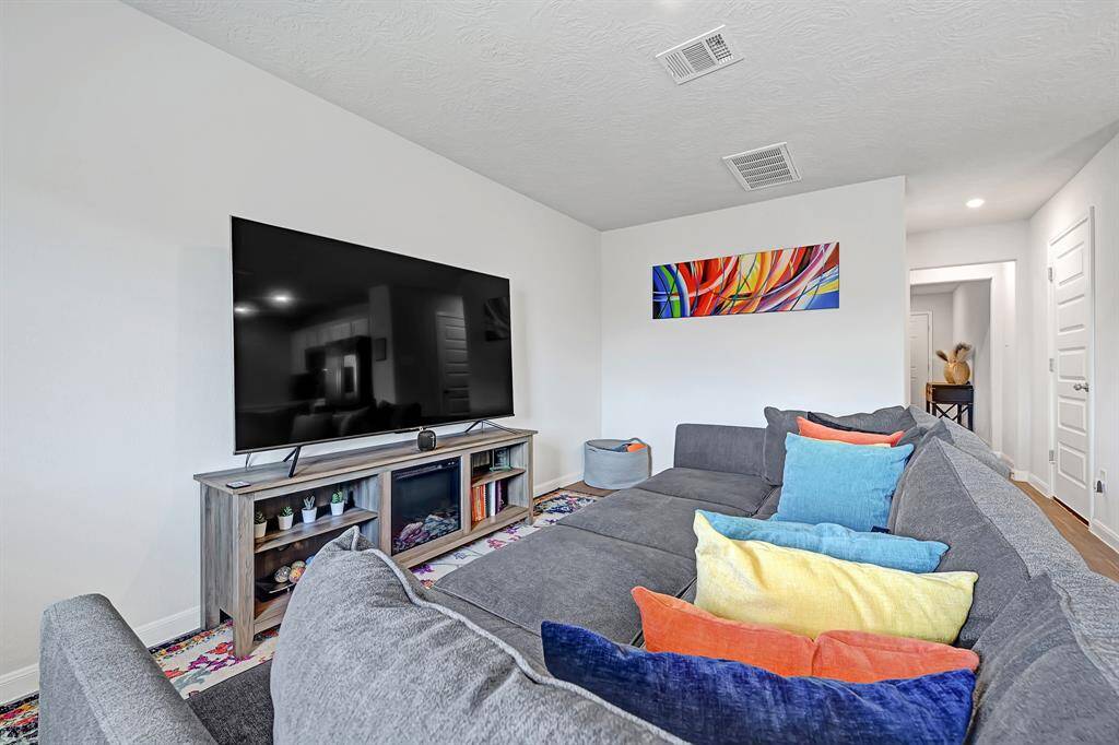 This cozy living room is bright and inviting, with a hallway leading to other areas of the home.