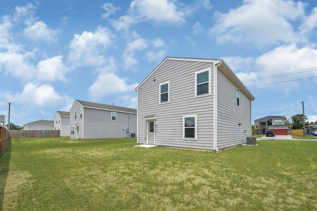 Beautiful new two-story house with light gray siding and white trim. It sits on a spacious, grassy lot, providing ample outdoor space.