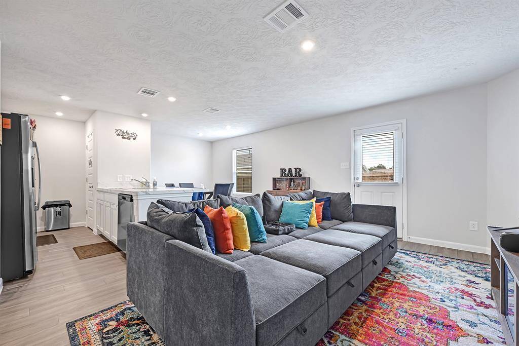 This inviting living space features an open floor plan & seamlessly connects to a modern kitchen with a breakfast bar.