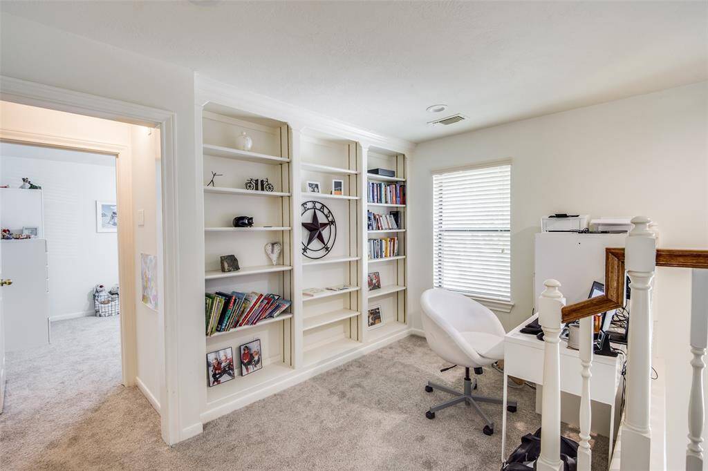 Immediately at the top of the stairs is a cozy sitting area with built-in shelving overlooking the foyer and family room on the ground floor.