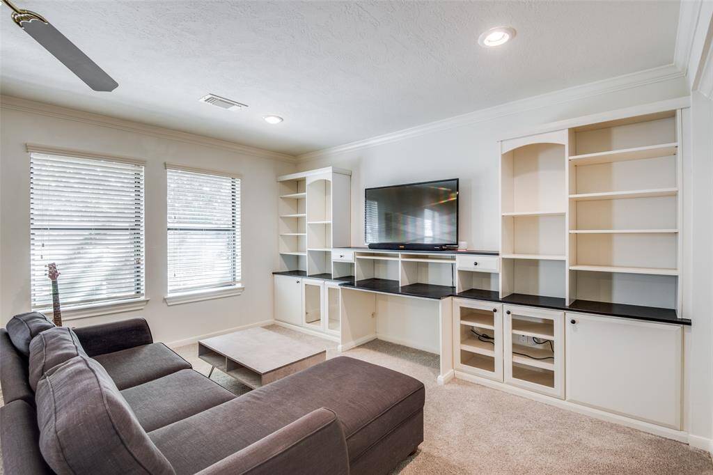 Down the hall located directly to the right of the stairs, you will find the huge open-concept game room with custom built-in shelving that offer plenty of storage. Not pictured to the right is the hallway that will lead you to the first secondary bedroom and bathroom.