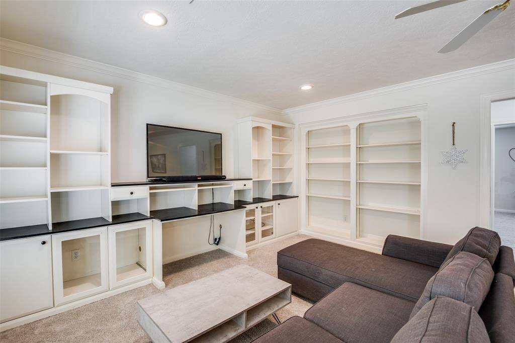 Another view of the open-concept game room with plenty of built-in shelving.