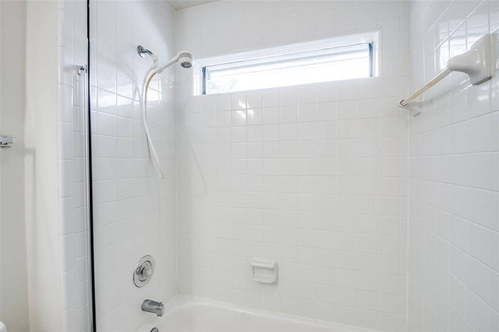 Another view of the secondary bathroom tub with shower.