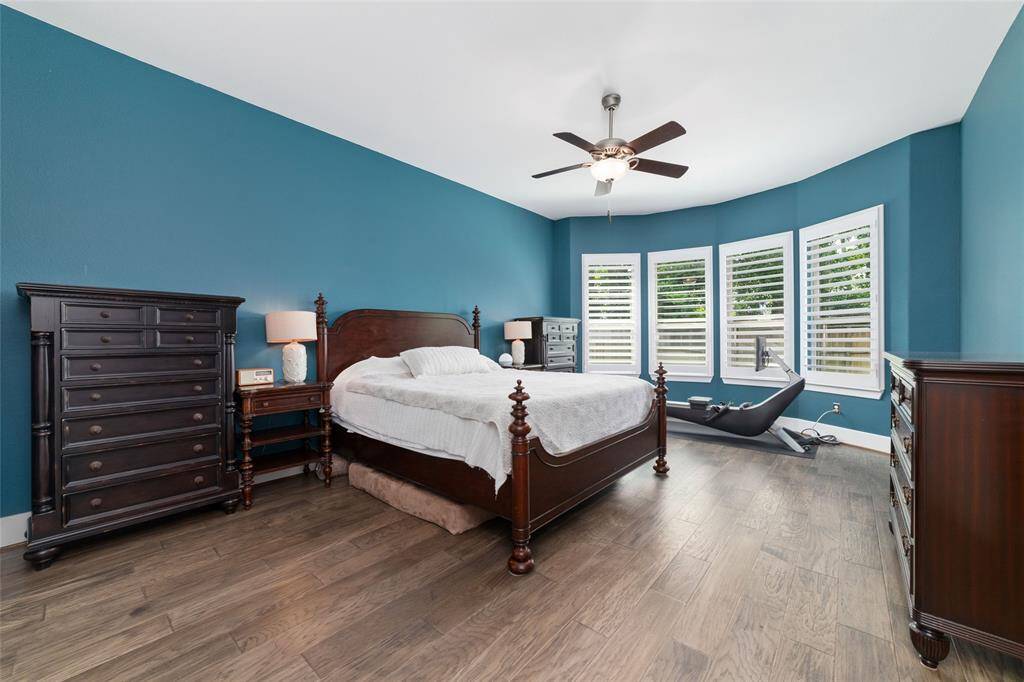 The primary suite is spacious and features bay windows with custom plantation shutters.