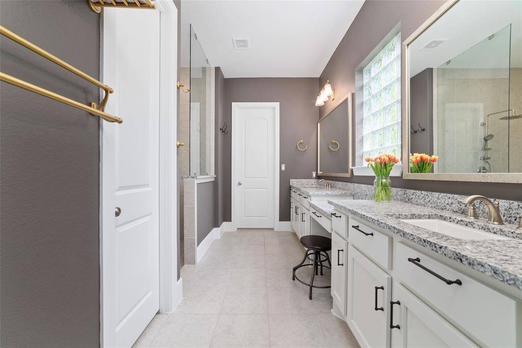 Spacious primary bathroom with private toilet room, extra large shower and his and hers vanities. The bathroom attaches to the primary closet and utility room.