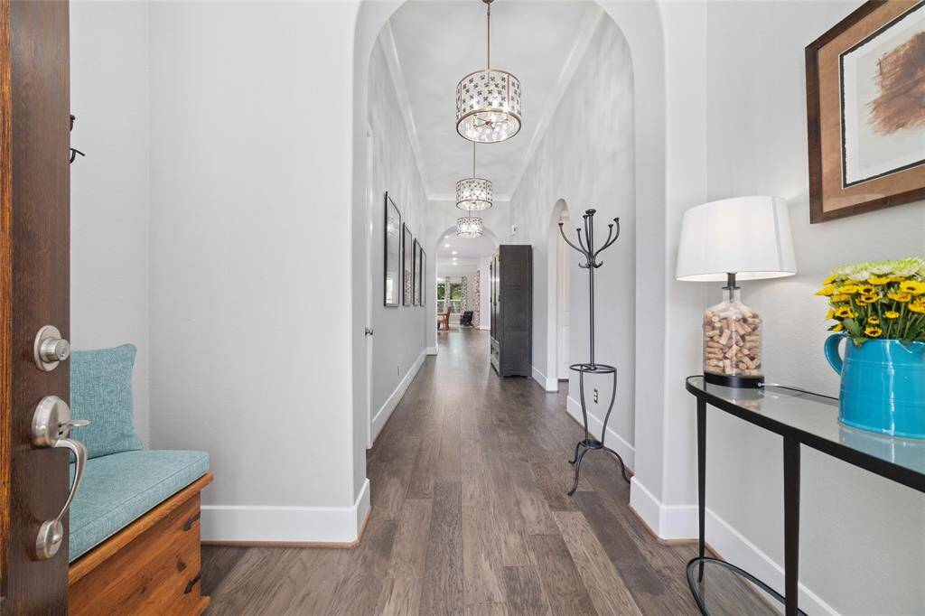 As you step inside you'll find a foyer and grand hallway adorned with Ballard Designs ceiling light fixtures.