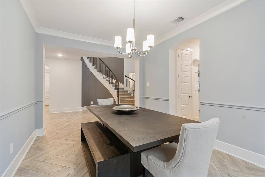 This photo showcases  the modern dining area. The the background you can see the elegant staircase.