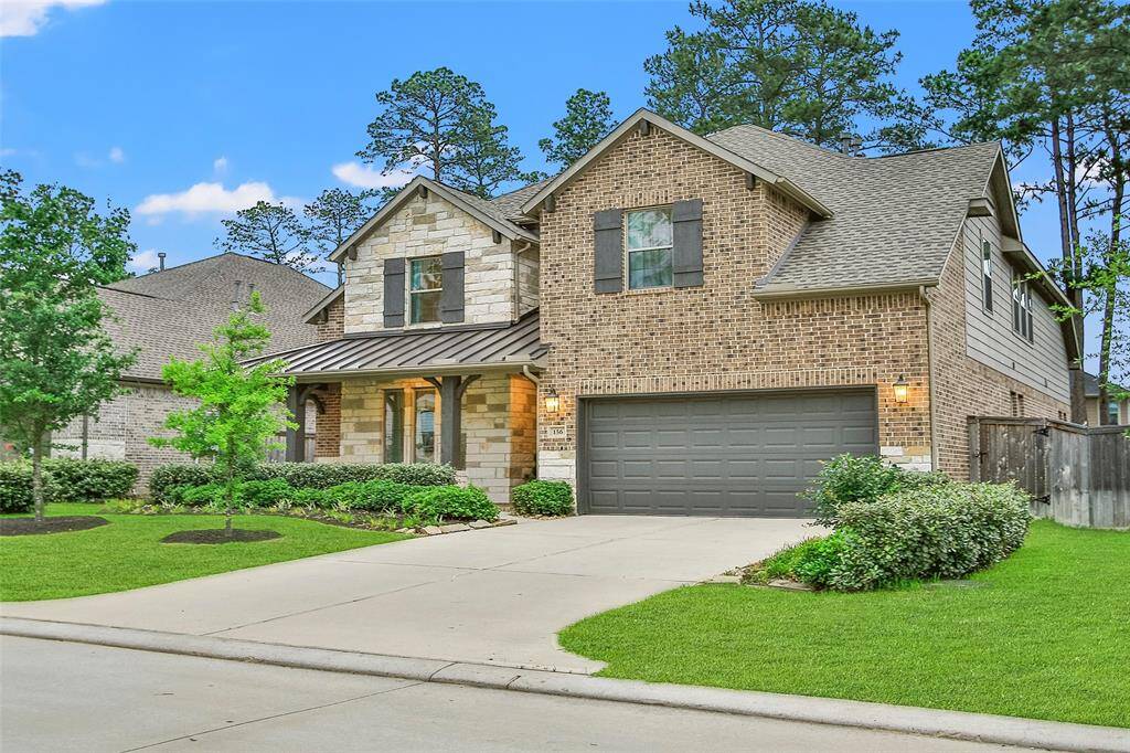 This charming two-story brick home features a spacious front yard with well-maintained landscaping. It has a covered porch, attached two-car garage, and is set in a peaceful neighborhood with mature trees in the background. Perfect for family living.