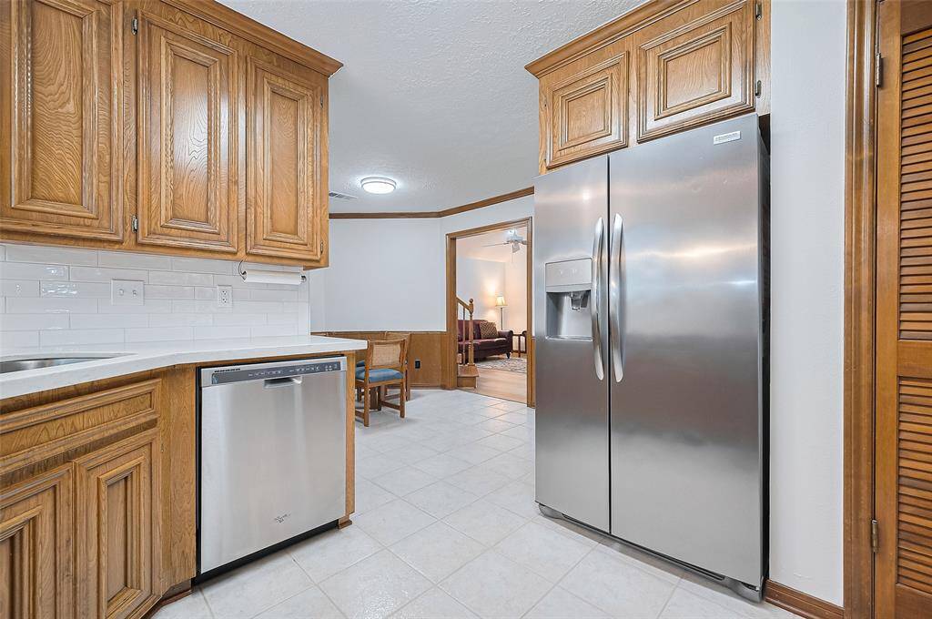 It comes with a stainless steel Frigidaire French-style side-by-side refrigerator featuring convenient water and ice in the door—perfect for quick access to cold drinks, reducing the need to open the fridge frequently, and helping conserve energy. The kitchen flows into the breakfast area, creating a functional layout for everyday living and casual dining.