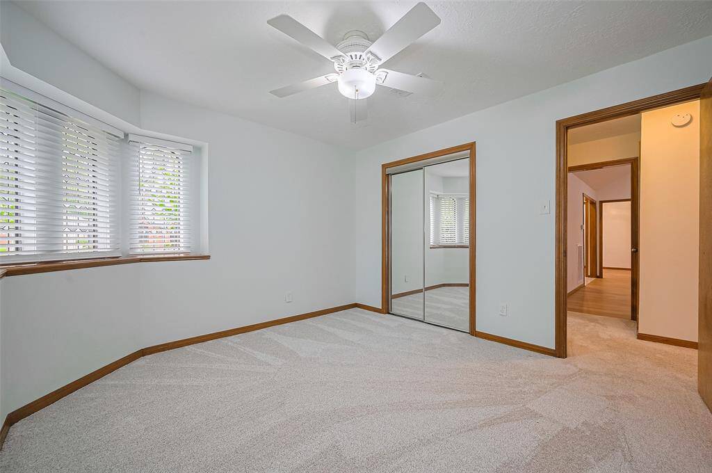 Bedroom #2 also includes a convenient ceiling fan and mirrored sliding glass closet doors. The mirrors help refract the natural light coming through the original leaded glass windows and side yard window, filling the room with an abundance of natural light and creating a bright, airy atmosphere.
