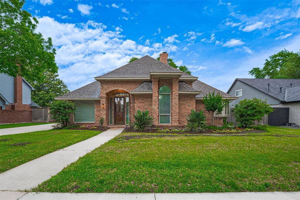 Charming traditional brick home with fresh exterior paint in 2024 for a clean, updated look. A walkway leads to the inviting covered patio and impressive 8-ft leaded glass front door with a refinished finish in 2025 and protective glass storm door—perfect for added insulation, security, and natural light. Full sprinkler system in both front and backyards keeps landscaping lush with ease.