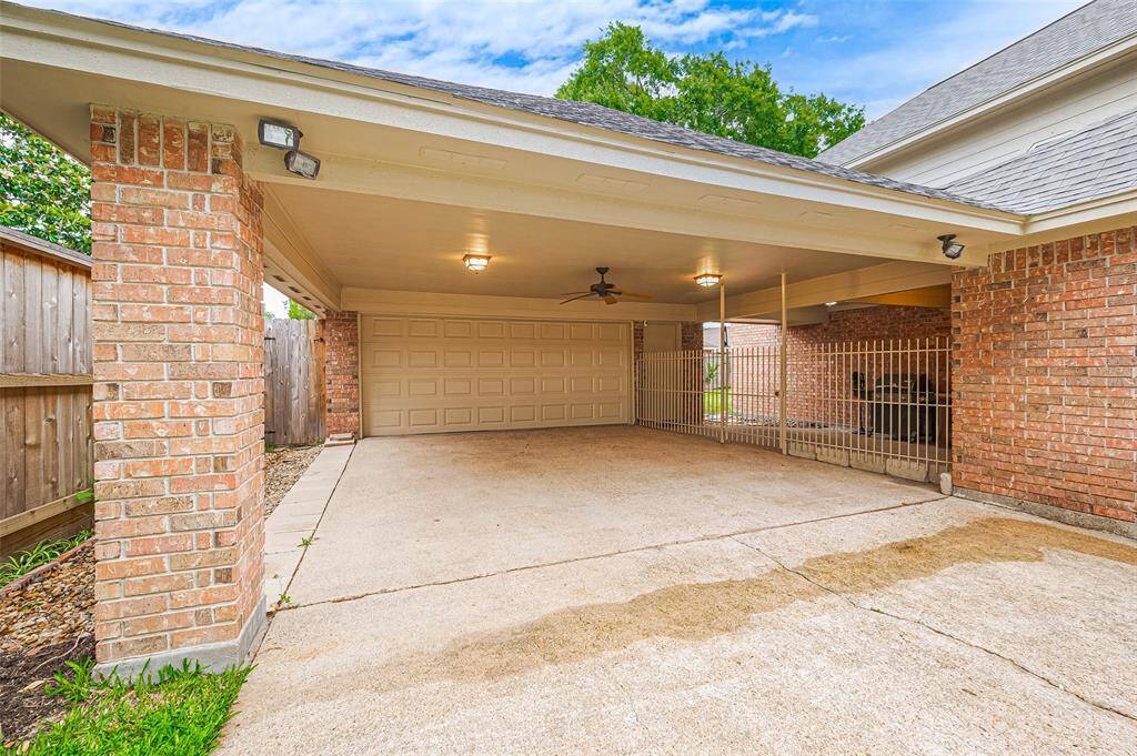 The two-car wide driveway leads to an attached porte cochère, which is lighted and features a ceiling fan for added comfort. Beyond the porte cochère is the 2-car garage, equipped with a garage door opener. Flood lights illuminate the driveway at night, enhancing security and convenience. The electrical panel was replaced in 2024, ensuring the home's electrical system is up to date and reliable.