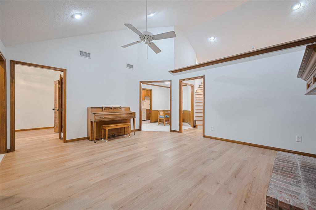 The living room, measuring 15'11" x 14'11", offers ample wall space for displaying furniture. The wall on the right separates the living room from the family room, creating a defined layout. A high vaulted ceiling adds an architectural feature, enhancing the room's open and airy feel.