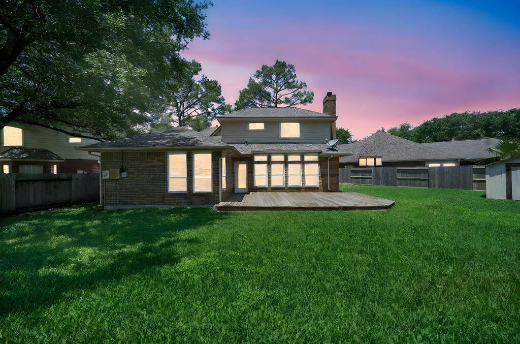 View of backyard shown at sunset.