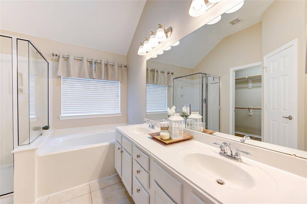 primary bath has double sinks, shower & tub