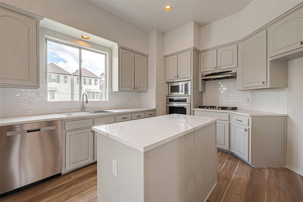 Discover elegance with sleek quartz countertops, enhancing both style and functionality in this beautiful kitchen.