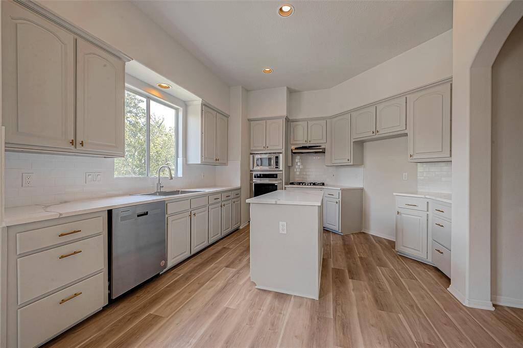 Discover this sleek, fully remodeled kitchen, boasting abundant natural light and modern finishes.