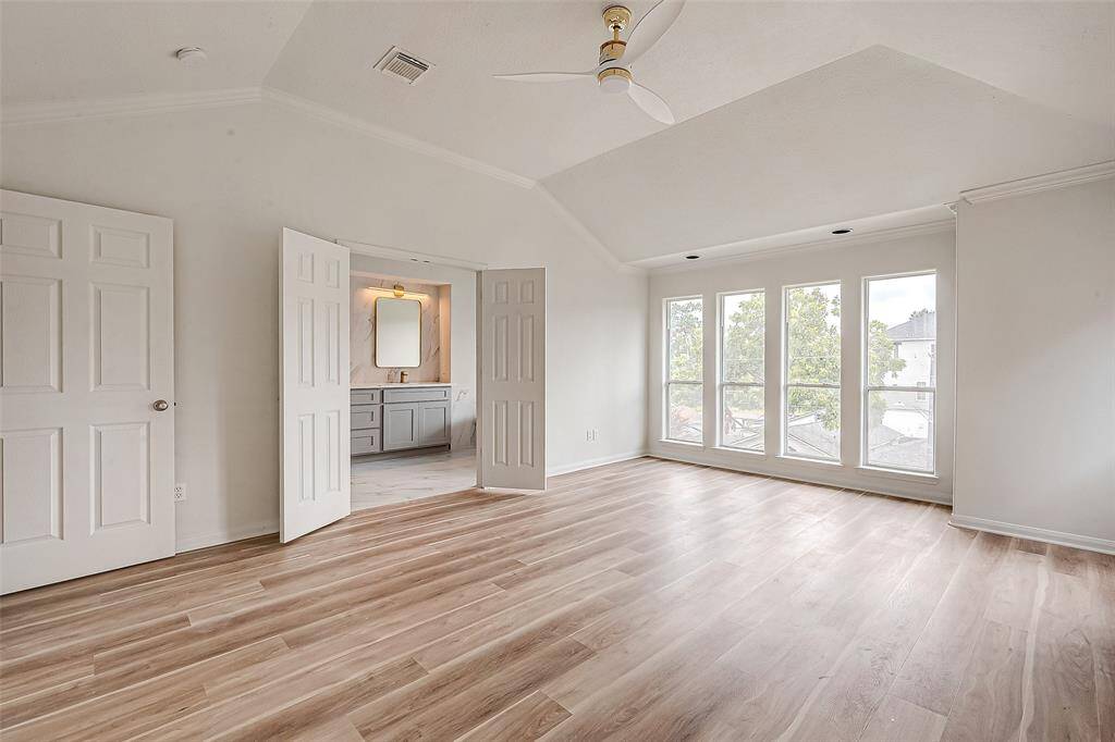Spacious master bedroom featuring abundant natural light and elegant flooring, with convenient access to a stylish en-suite bathroom.