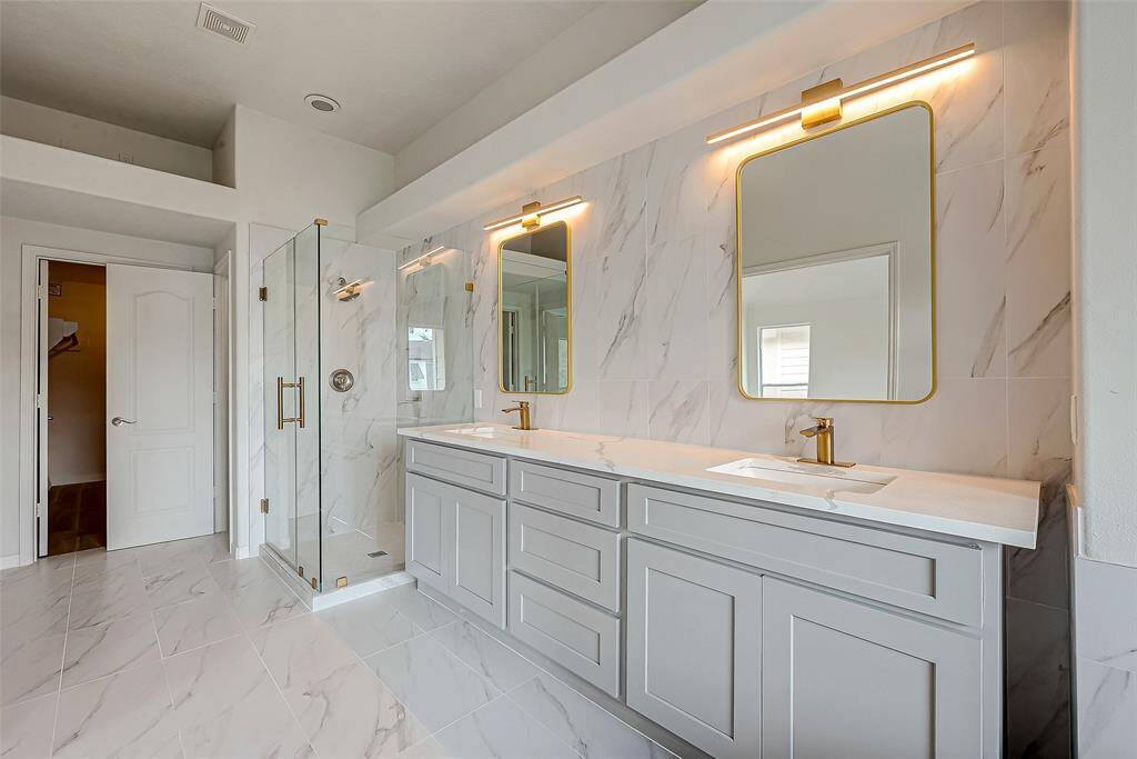 Sleek brass mirrors and lights add a touch of modern elegance.