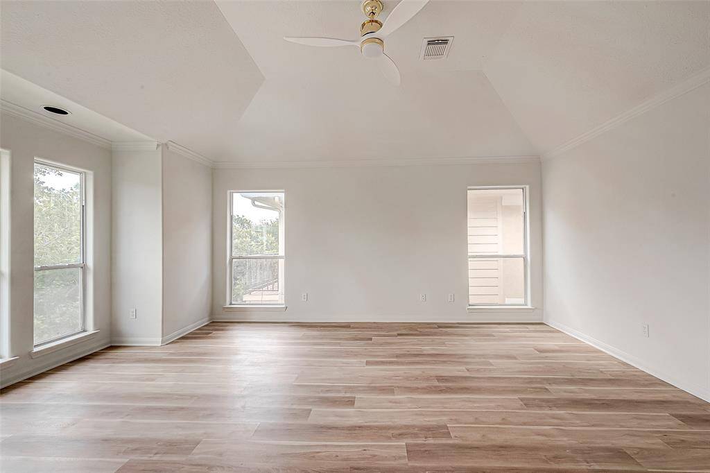 Expansive master bedroom filled with natural light from multiple large windows.