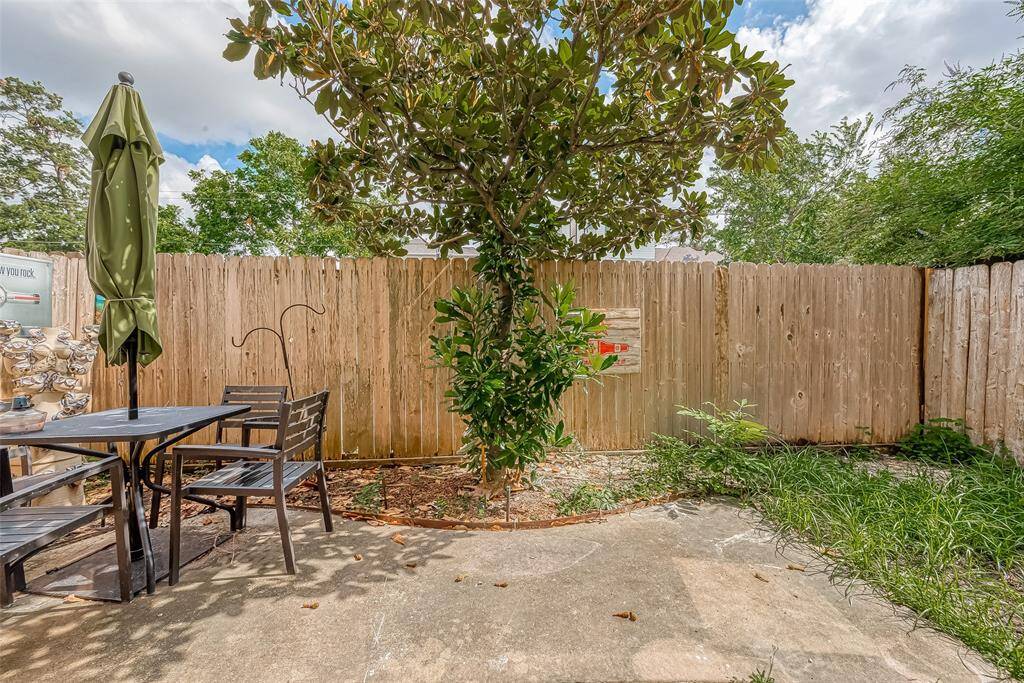 Charming patio with a lovely magnolia tree offers a serene outdoor retreat.