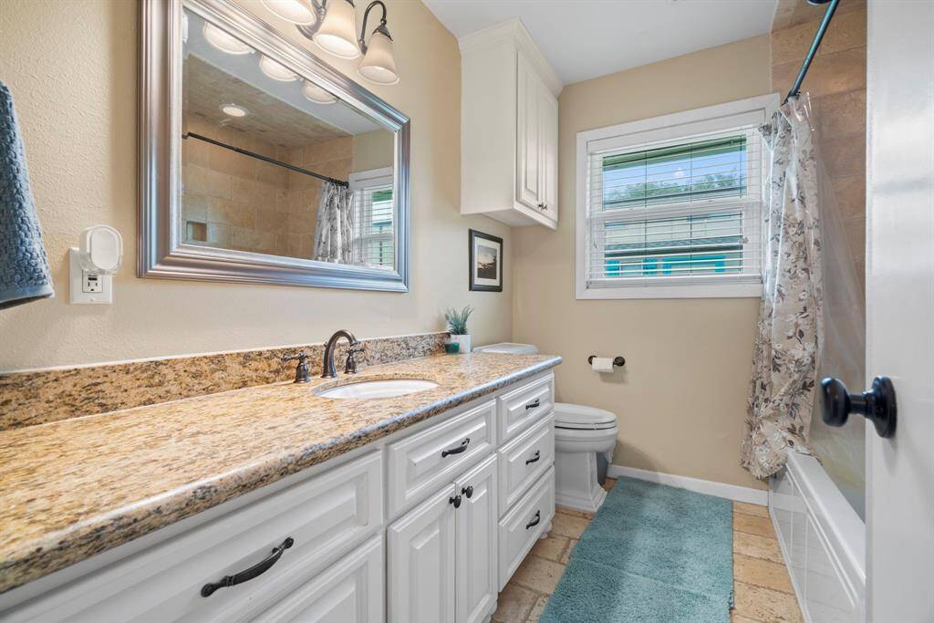 Secondary bathroom includes plenty of counter space and updated tile in the shower