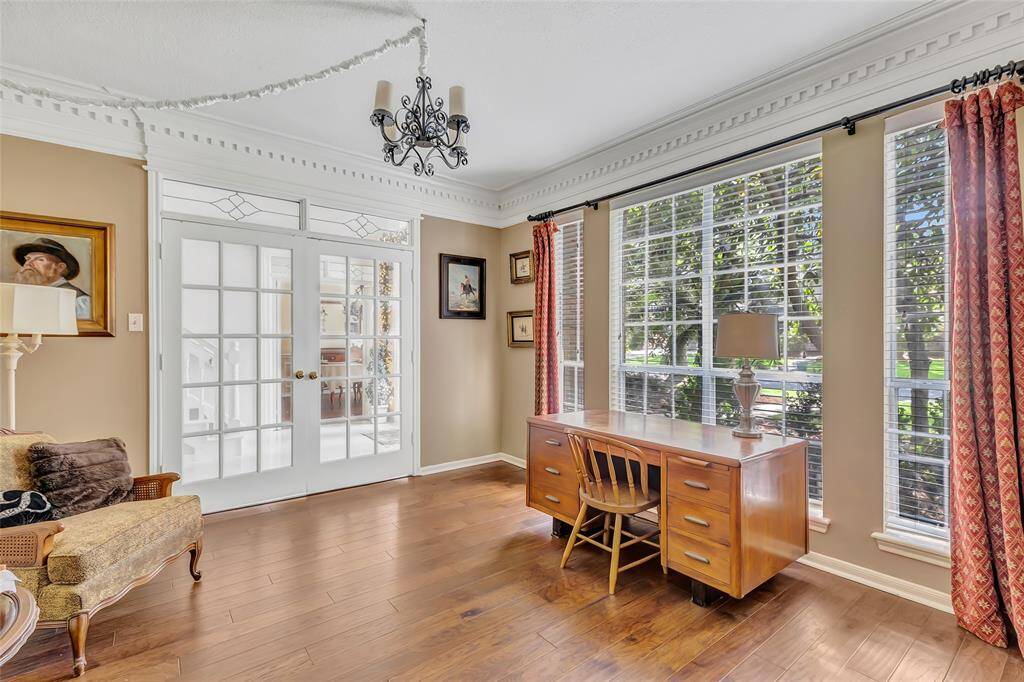 Another view of the study with French doors with a wall of windows and plenty of natural light.