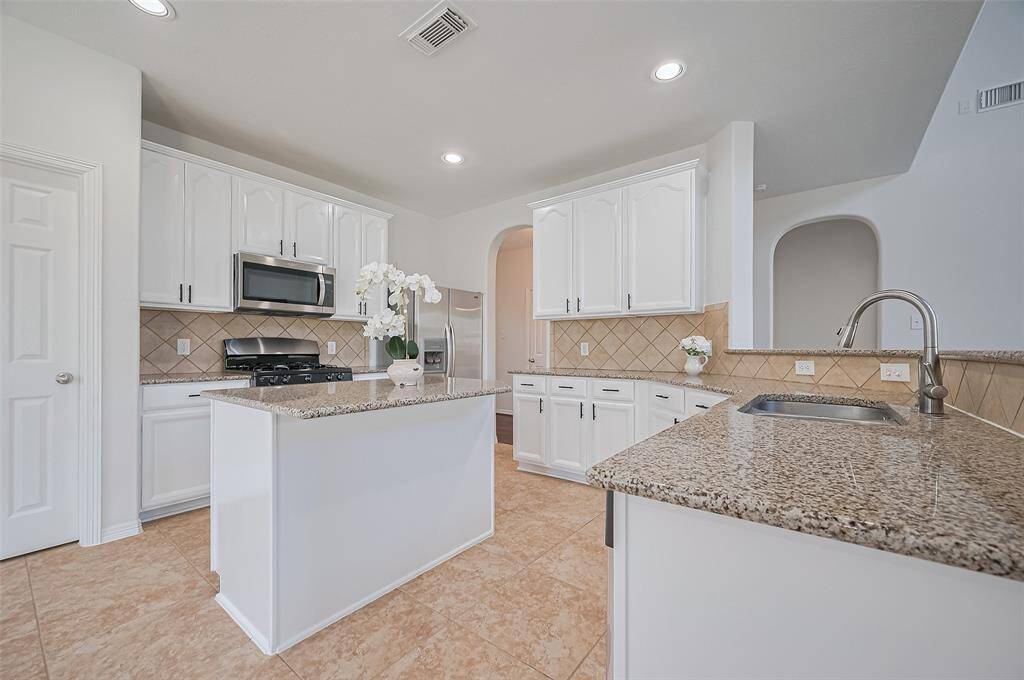 Smooth, polished quartz countertops create a refined, high-end feel while offering the perfect surface for everyday cooking.