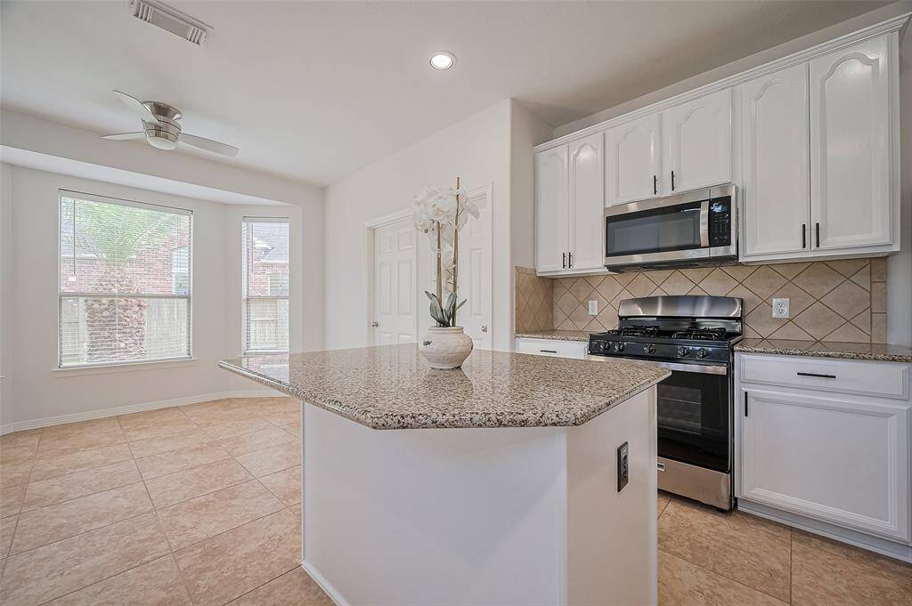 Newly painted cabinetry brings a crisp, modern look to the kitchen, offering a clean and inviting space for cooking and entertaining.