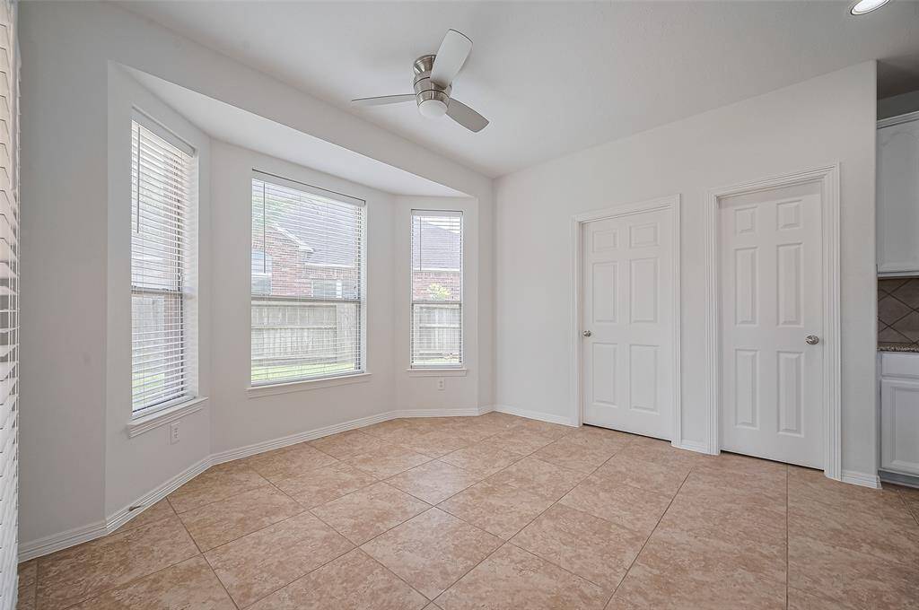 The dining room is bathed in natural light from large windows, enhancing its spacious feel and creating a perfect setting for family dinners.