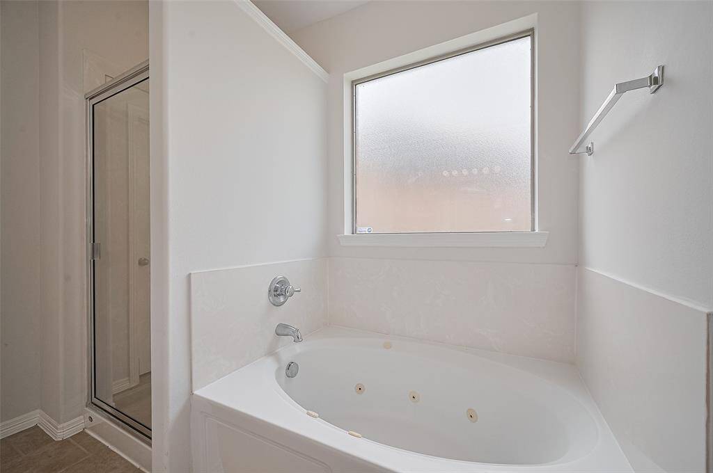 Spa-inspired primary bath with soaking tub and tile surround.