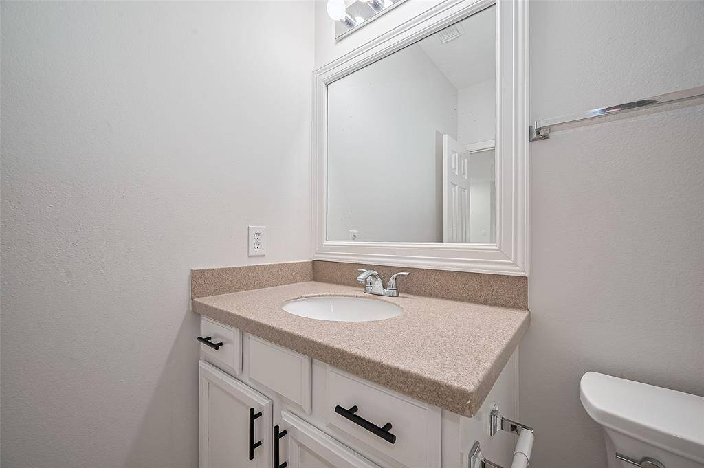Clean-lined cabinetry adds storage to the en-suite bath.