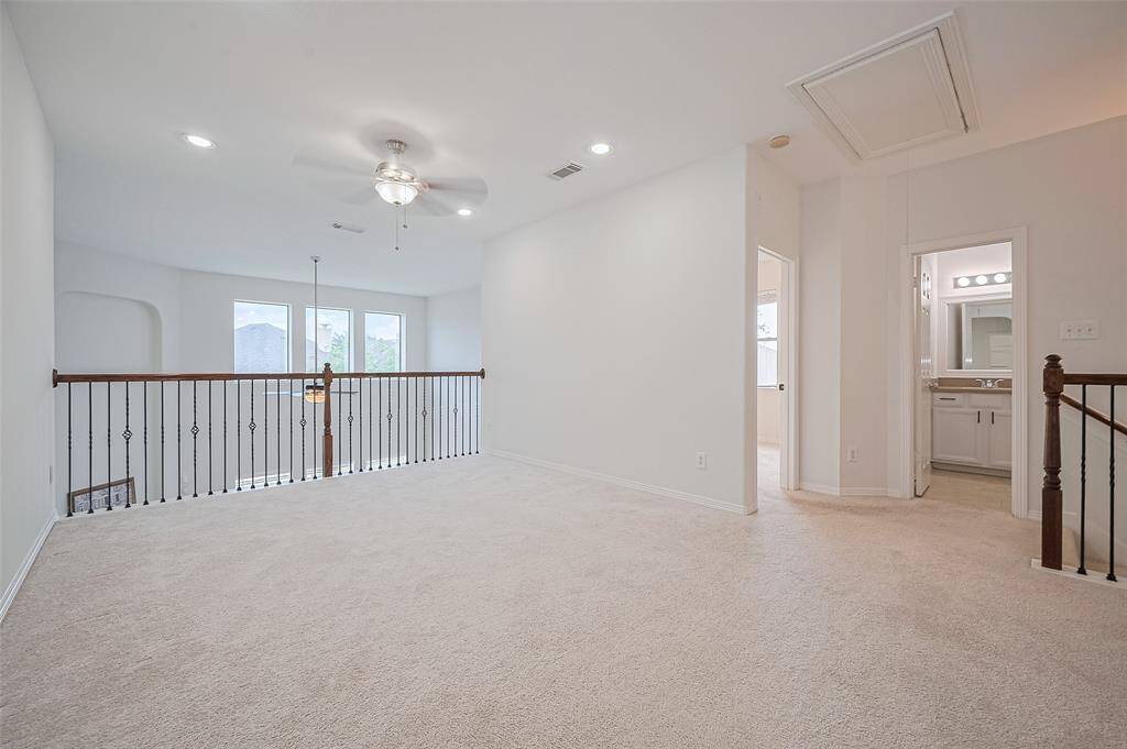 Upstairs landing with sitting area and open railing.