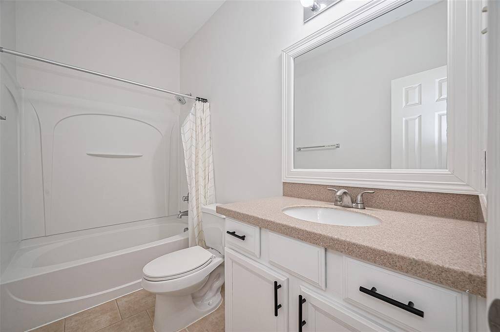 Featuring custom cabinetry, chic hardware, and a clean design, this bathroom is both functional and visually striking.