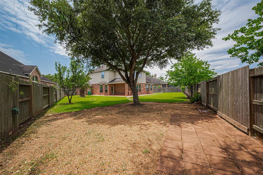 A fully fenced sanctuary with mature trees, manicured lawn, and room to relax or play.