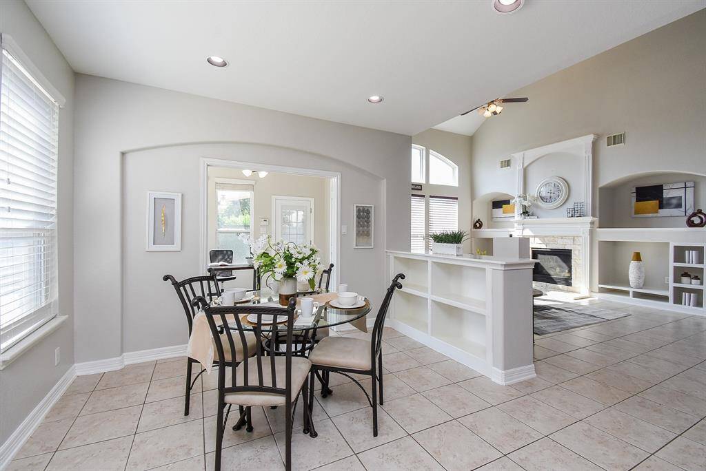 Nestled beside the kitchen, the bright breakfast area is filled with morning light from a large window. French doors open to a private office nearby.