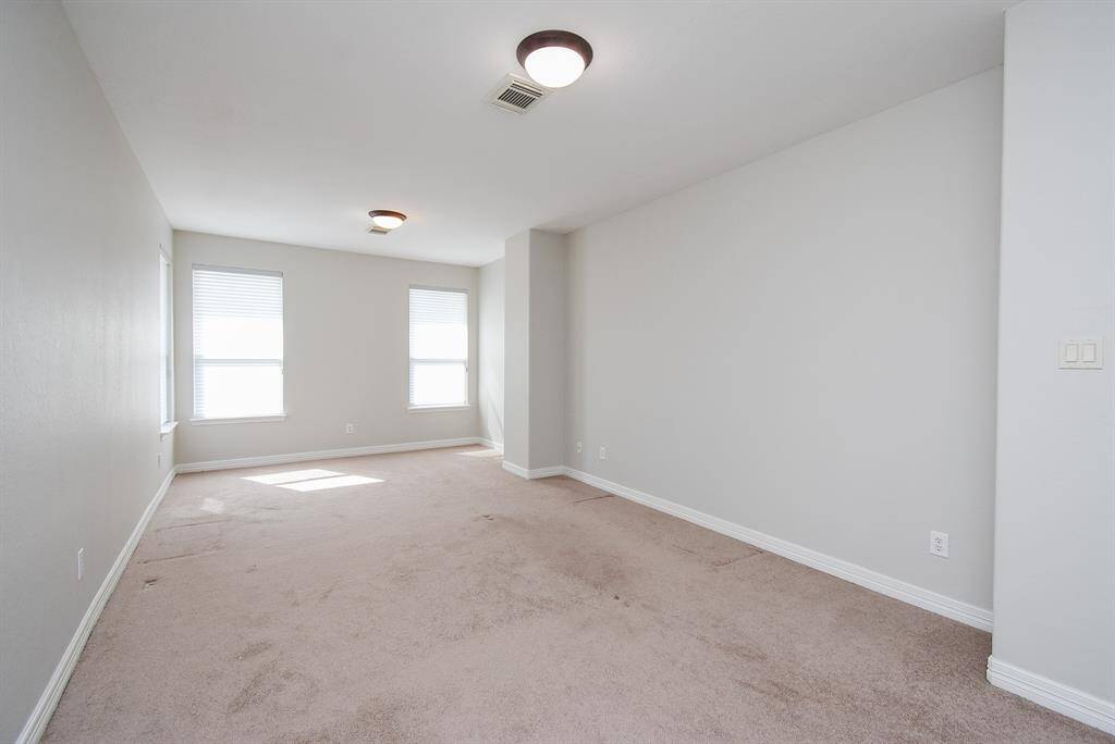 This expansive second-level room is ideal for movie nights or as a den, with plush carpeting, surface-mount lighting, and generous windows that maintain a light feel.