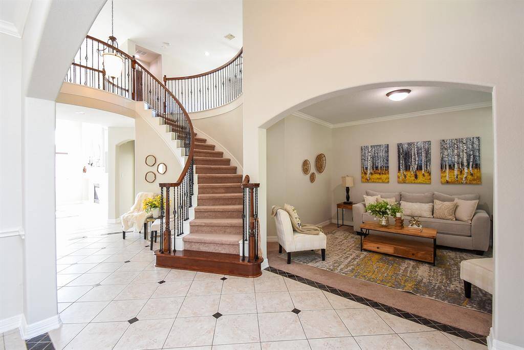 Just off the entry, this refined living space sits beneath a wide archway and adjacent to a sweeping curved staircase. Ideal for conversation or quiet moments, and perfect for receiving guests.