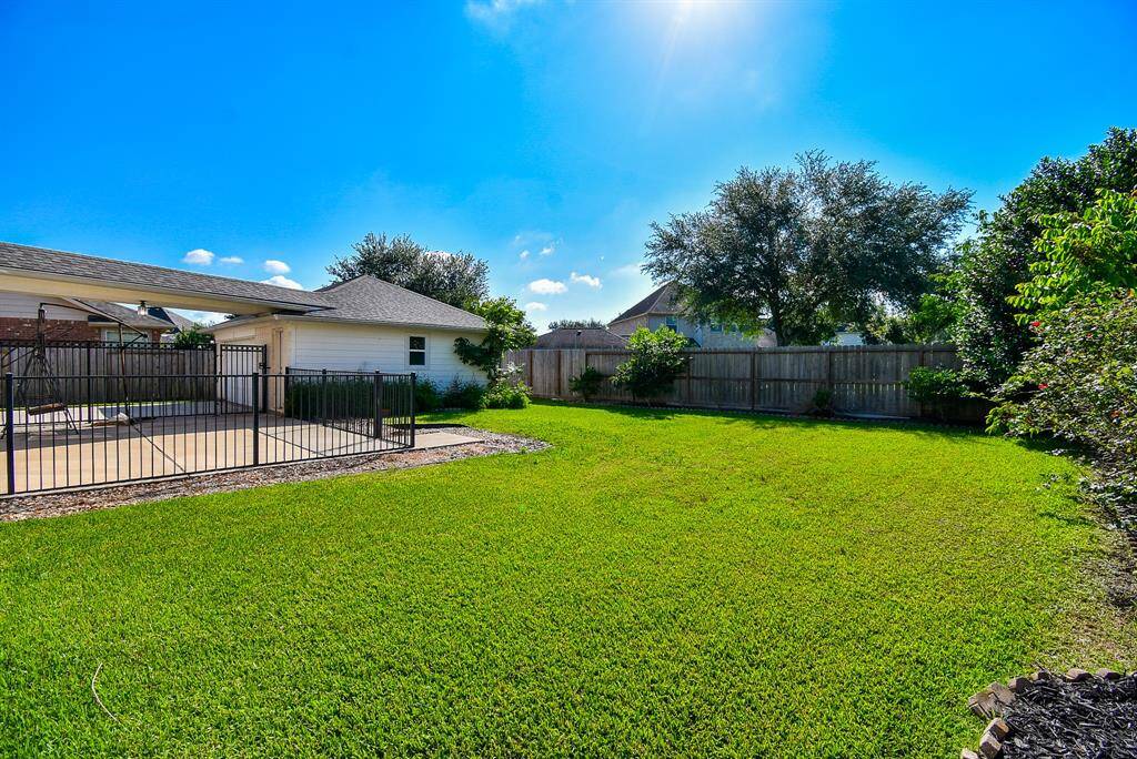 Step outside to a large, partially covered patio ideal for outdoor entertaining, morning coffee, or simply enjoying the open air. The expansive, fenced backyard offers abundant green space for recreation or relaxation. In the far corner, the detached 2.5-car garage stands out—not only upgraded with extra storage space, but also featuring a climate-controlled room that was previously used as a dog suite. This flexible space can easily serve various purposes.