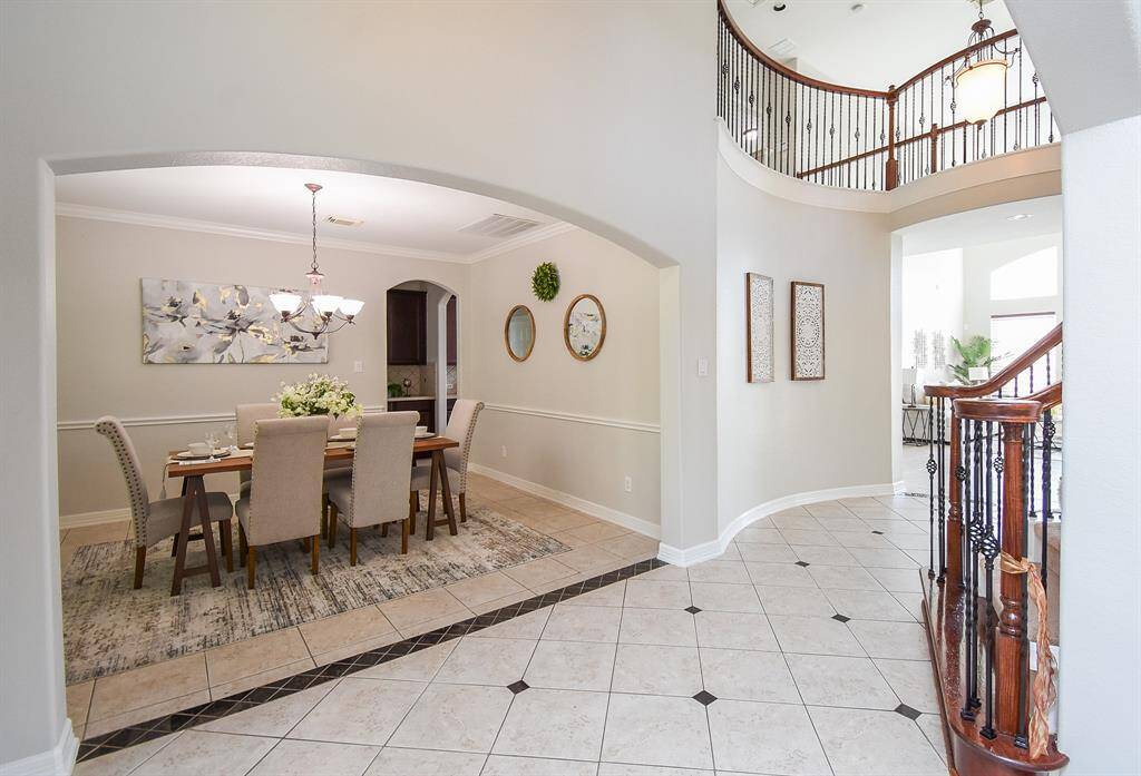 Across from the formal living space, the dining room is framed by tall windows and warmed by a stylish chandelier. This intimate yet airy space provides direct access to the kitchen, making it convenient for hosting dinners in style.