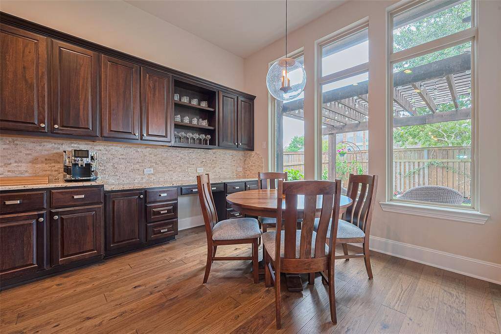 Tucked at the back of the kitchen, the planning center offers a perfect space for homework, daily organization, or quiet reflection—all while enjoying a lovely view of the beautifully landscaped backyard. The updated light fixture above the kitchen table adds a stylish, modern touch to the space