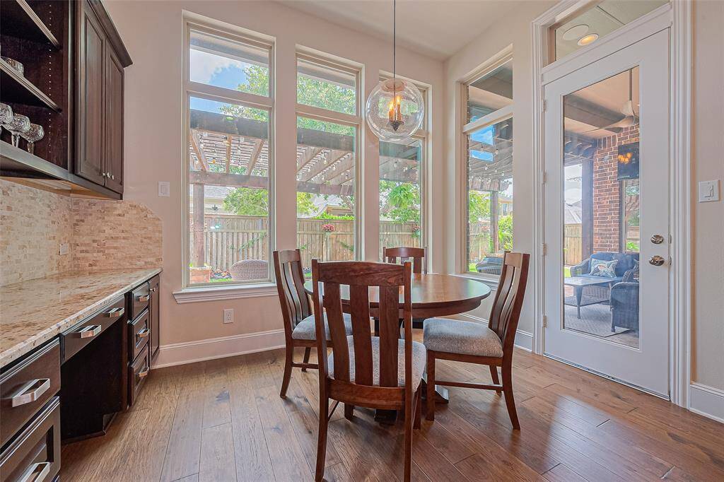 Natural light pours in through an abundance of windows, creating a bright and welcoming atmosphere. This view also showcases easy access to the fantastic back patio—perfect for enjoying your morning coffee or unwinding with an evening toast