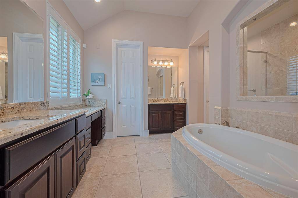 Relax and unwind in the spacious primary bath, featuring a separate soaking tub, a large shower, dual sinks, and an expansive vanity for ample storage