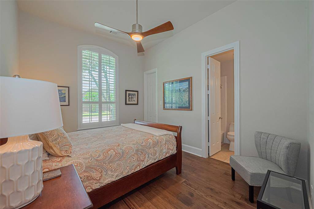 Heading back toward the front of the home, you'll find one of three secondary bedrooms, featuring the same beautiful wood flooring, an updated ceiling fan, and classic Plantation shutters. This room shares a full Jack-and-Jill bath with an adjoining bedroom